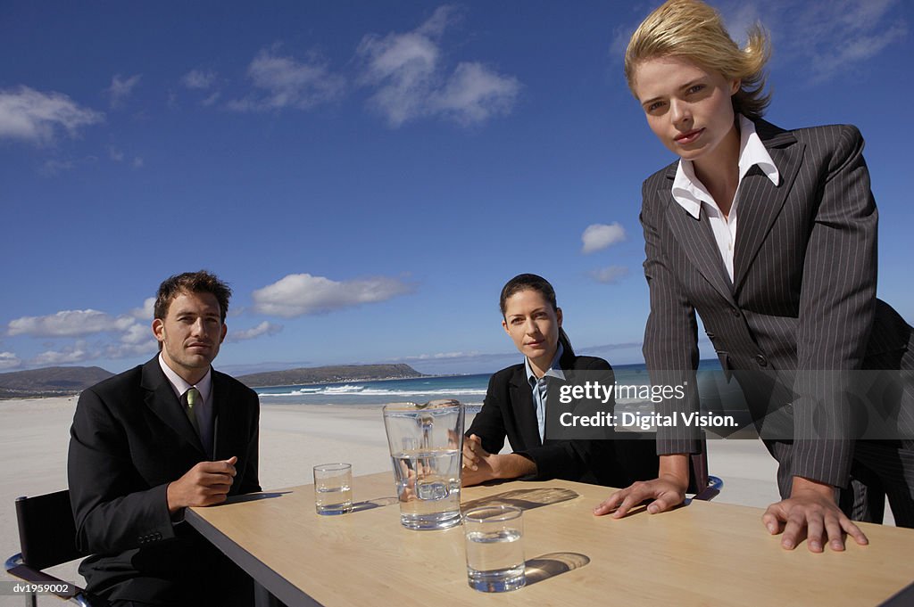 Serious Businessman and Businesswomen Having a Meeting Outdoors on a Beach