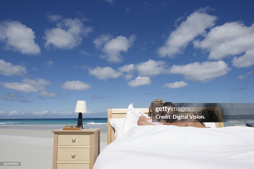 Couple Sleeping in a Bed on the Beach