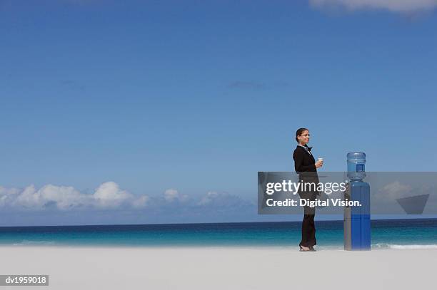 businesswoman standing next to a water cooler - digital devices beside each other bildbanksfoton och bilder