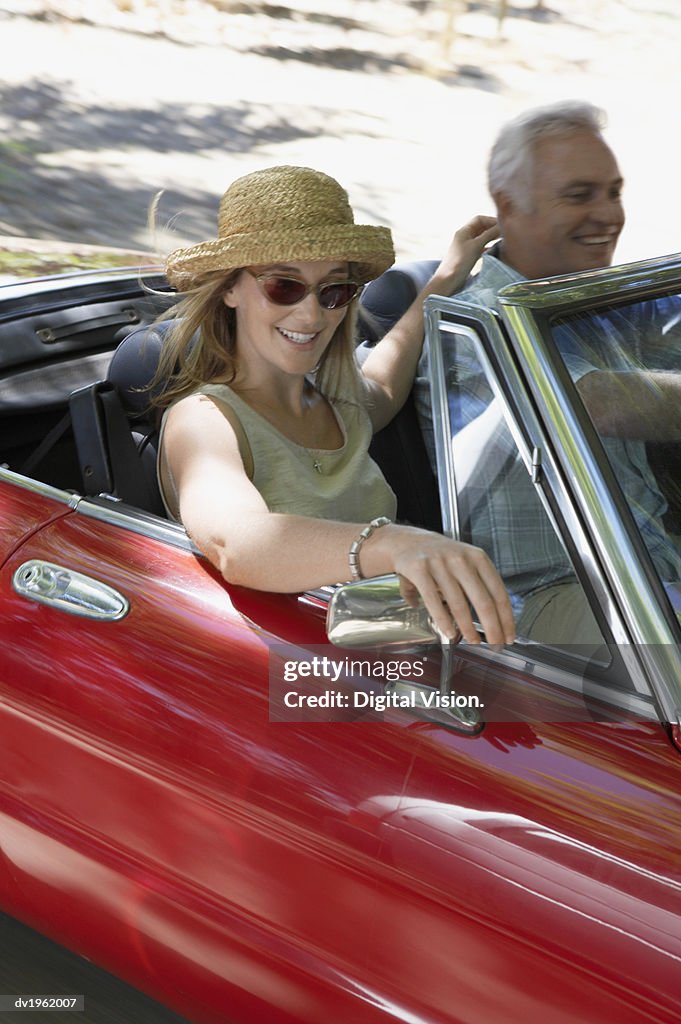 Couple Driving in a Red Convertible