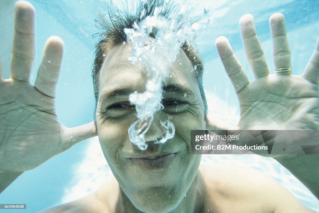 Man Underwater Pulling a Funny Face