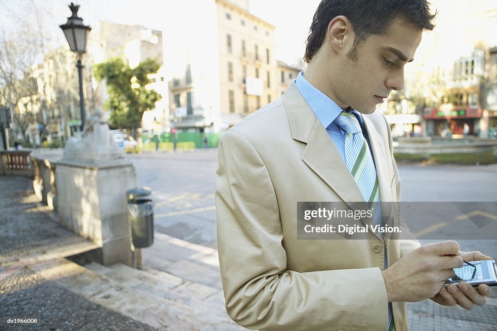 Businessman Standing Outside Using His Handheld PC