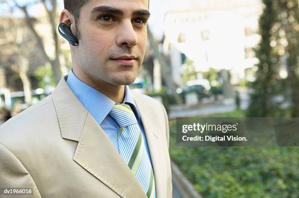 smart businessman wearing a hands-free device - smart 個照片及圖片檔