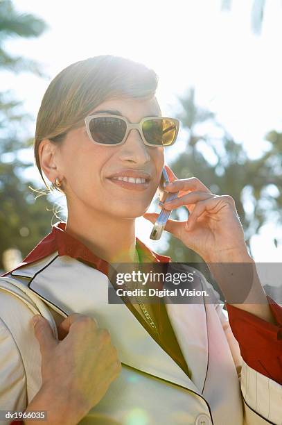 smart businesswoman in sunglasses talks on her mobile phone - smart 個照片及圖片檔