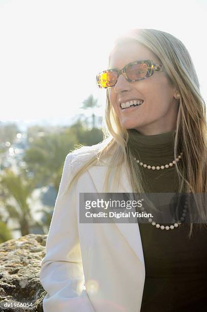woman wearing sunglasses and a pearl necklace looking sideways - pearl imagens e fotografias de stock