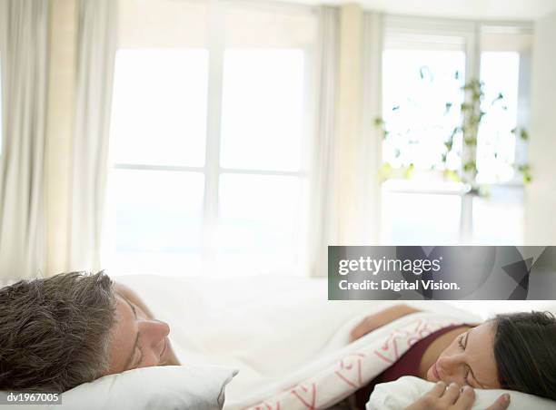 couple lie in bed, sleeping, sunlight coming through the window - people coming of age purify with icy water in tokyo stockfoto's en -beelden