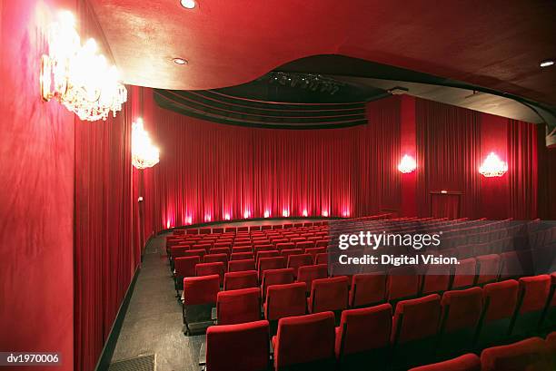 empty illuminated theatre - kinosaal stock-fotos und bilder