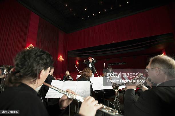 orchestra performing in a theatre - blasinstrument stock-fotos und bilder