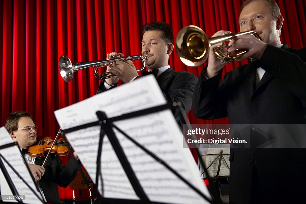 Male Trumpeters and Violinist Perform in an Orchestra