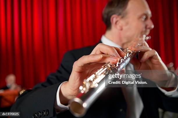 close-up of a male flautist performing a solo - soloist stock pictures, royalty-free photos & images