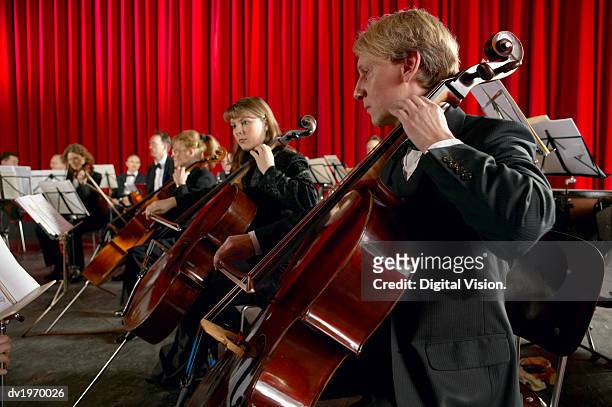 cellists performing in an orchestra - violin family stock pictures, royalty-free photos & images