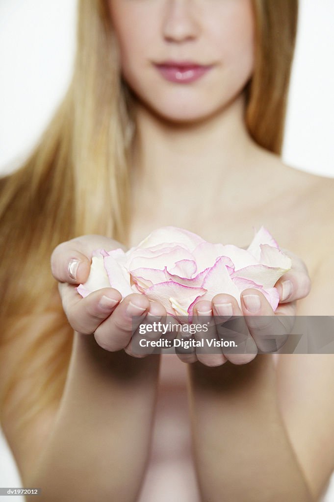 Mid Section View of a Young Woman Holding Rose Petals in Her Cupped Hands