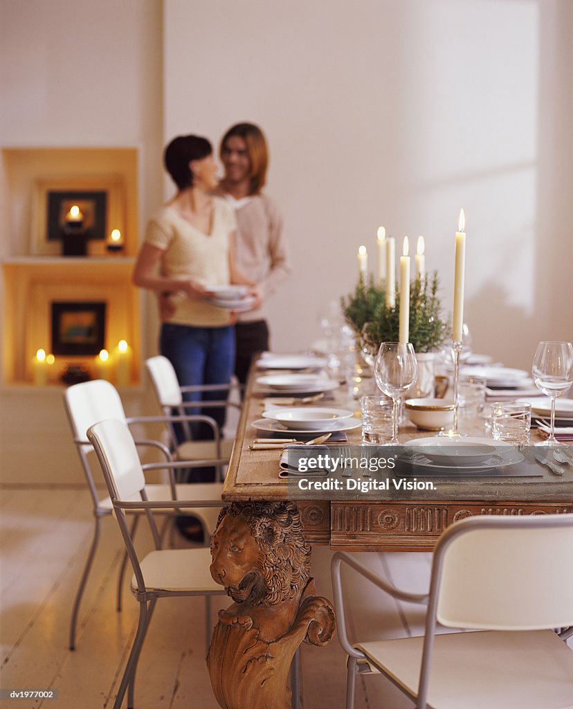 Couple Standing in a Dining Room Next to a Wooden Dining Table