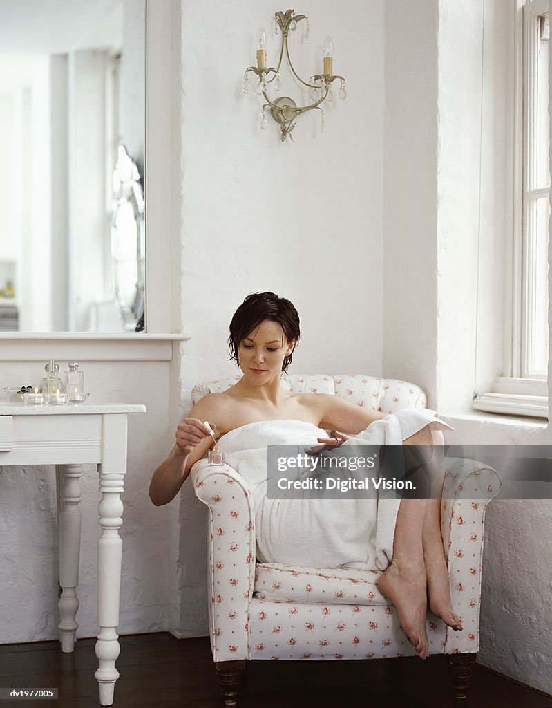 Woman Wrapped in a Towel and Applying Nail Varnish