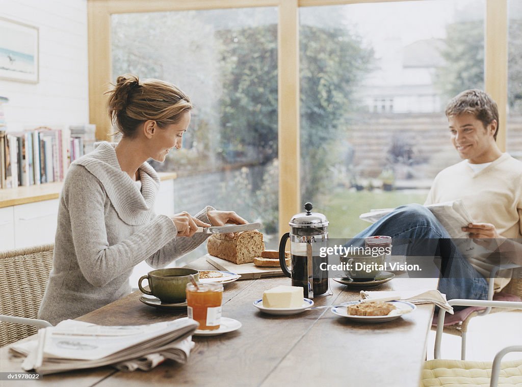 Couple Sits at a Kitchen Table Having Breakfast