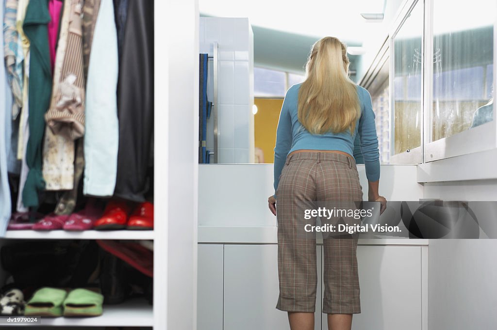 Rear View of a Blond Woman Looking at a Mirror