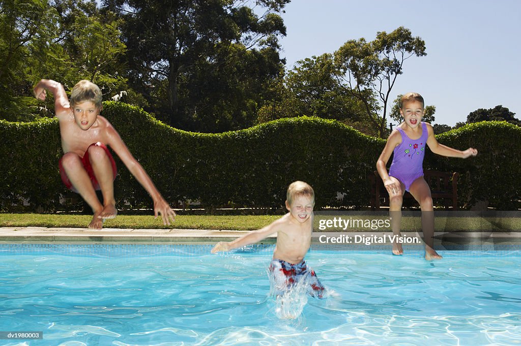 Young Children Jumping into a Swimming Pool