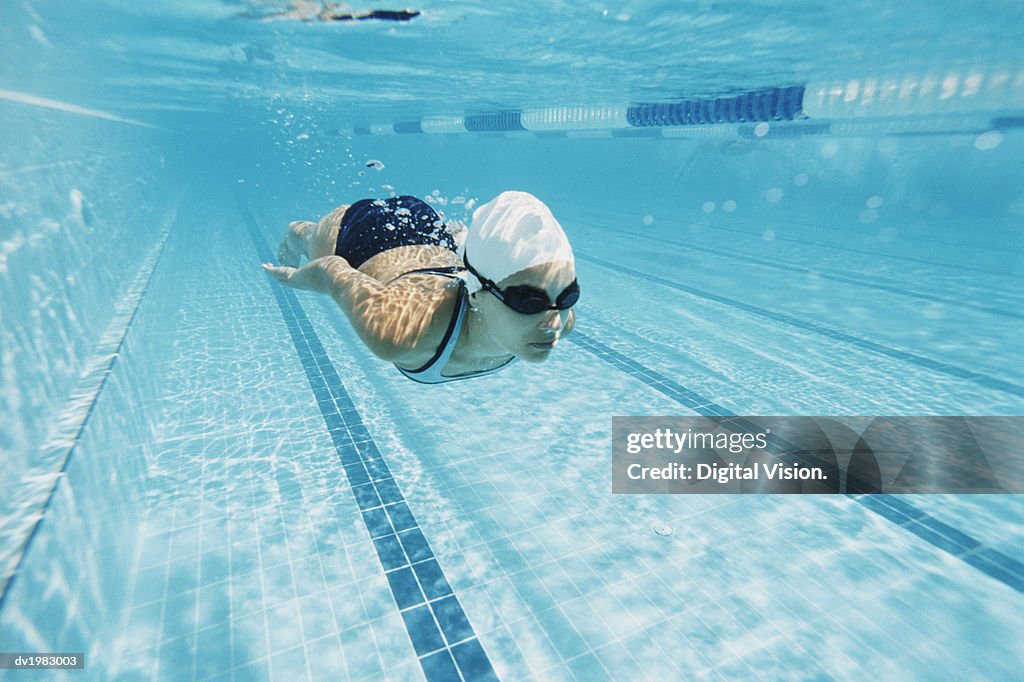 Young Woman Swimming in a Pool Underwater