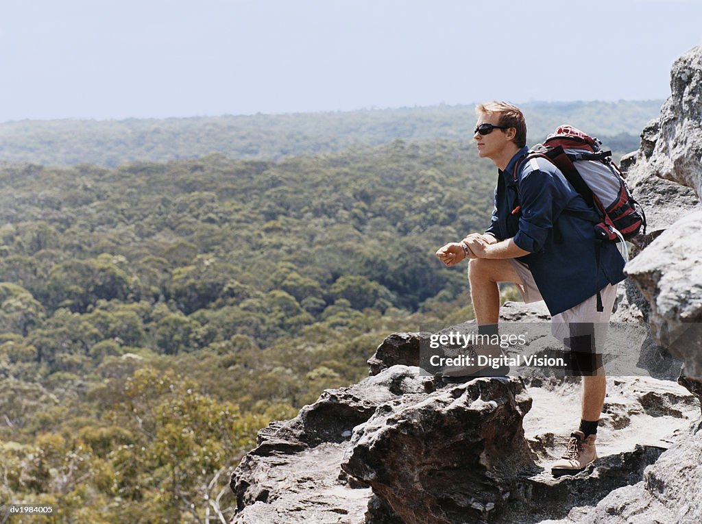 Man Standing on a Mountain Summit Looking at View