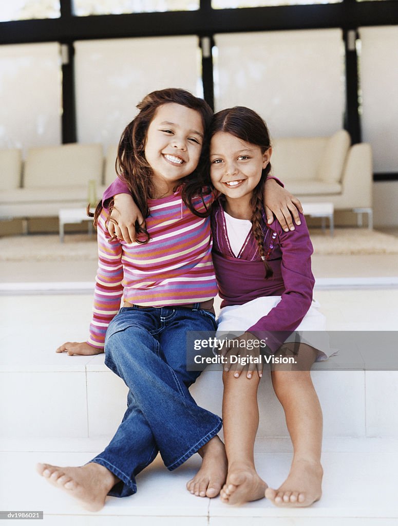 Portrait of Two Young Girls Sitting Side by Side on Patio Steps