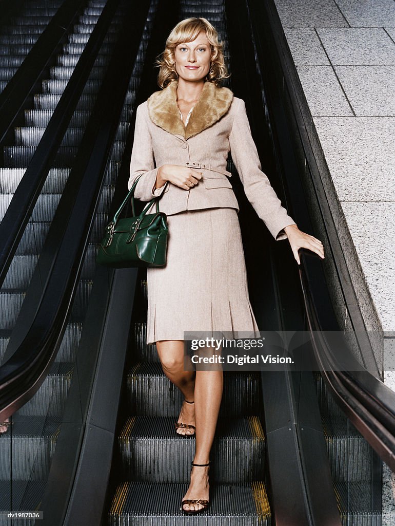 Portrait of a Young, Well Dressed Woman Standing on an Escalator