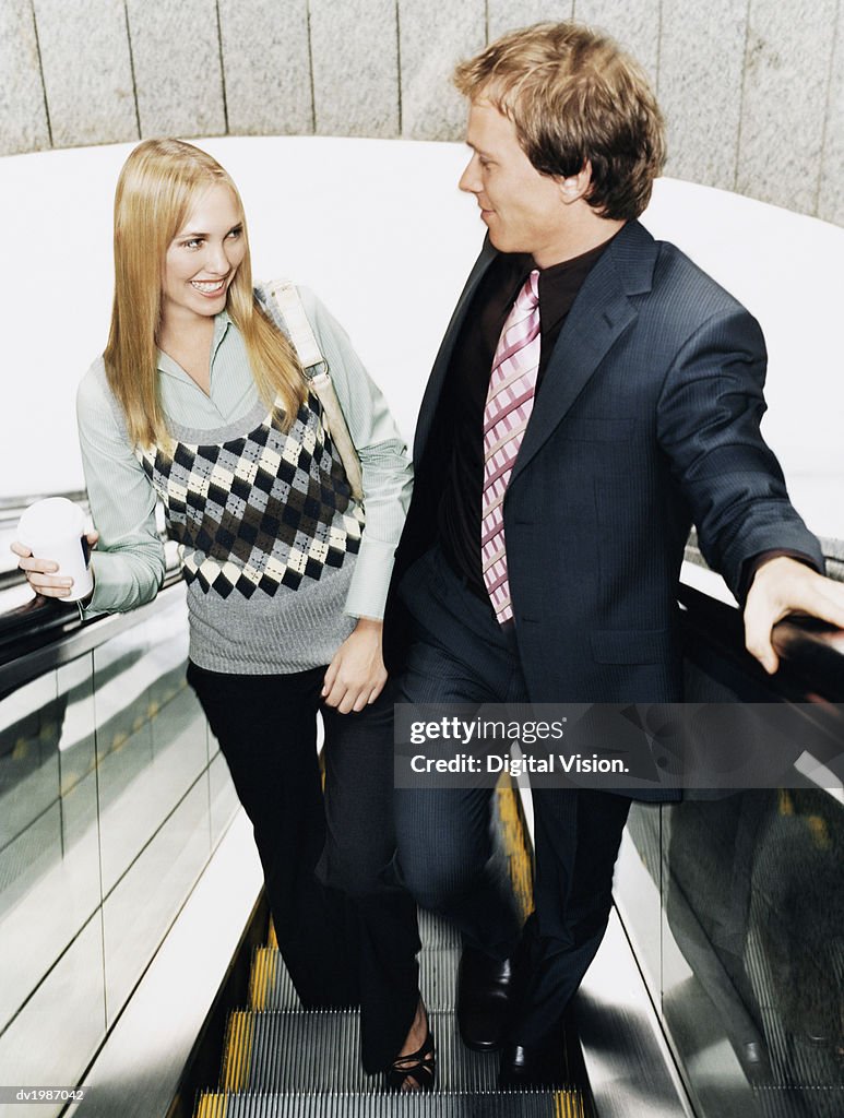 Two Businesspeople Standing on an Elevator Looking Face to Face