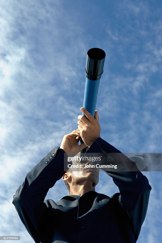 Low Angle View of a Businessman Looking Through a Telescope