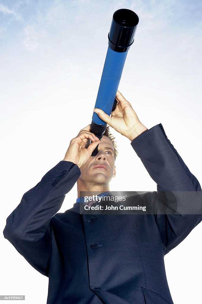 Low Angle View of a Businessman Looking Through a Telescope