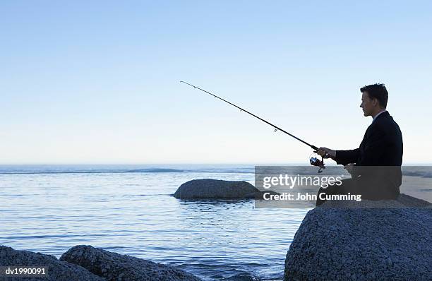 https://media.gettyimages.com/id/dv1990091/photo/businessman-fishing-from-a-rock.jpg?s=612x612&w=gi&k=20&c=6HiedRw32mHg-kg4COdyfZvLktfP2IjfId5LqH7Wcxc=