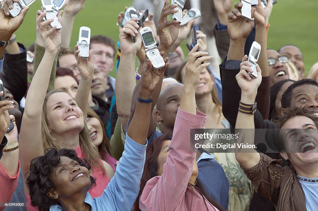 Large Crowd of People Holding Mobile Phones in the Air