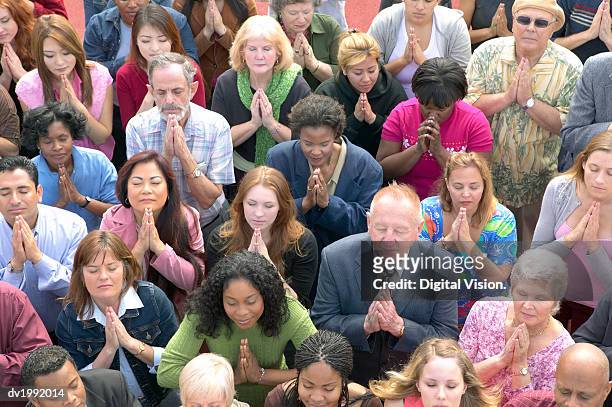 elevated view of a crowd of people praying - religion stock-fotos und bilder
