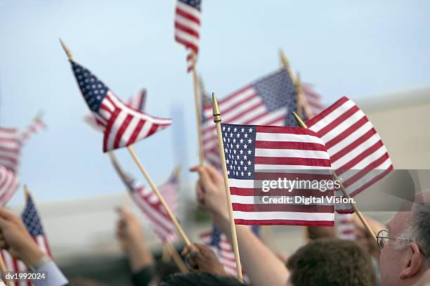 crowd waving stars and stripes flags - citizenship stockfoto's en -beelden