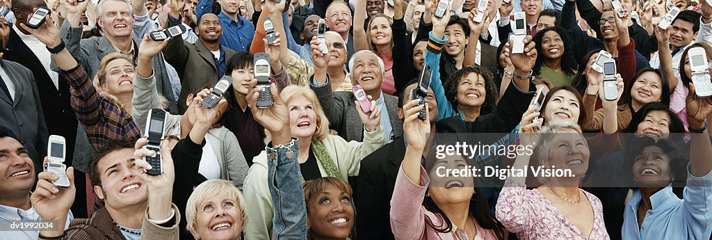 Large Crowd of People Holding Their Mobile Phones in the Air