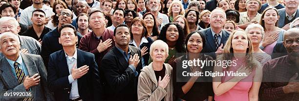 large crowd of people pledging allegiance - hand aufs herz stock-fotos und bilder