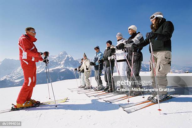 ski trainer with men and women on a ski slope - coach travel stock pictures, royalty-free photos & images