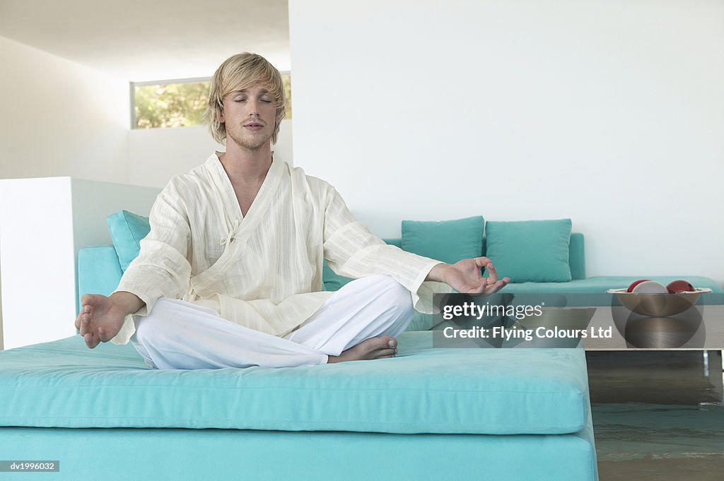 Man Sits in the Lotus Position With His Eyes Closed