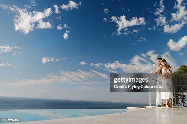 couple standing poolside on a scenic coast - voyage15 photos et images de collection