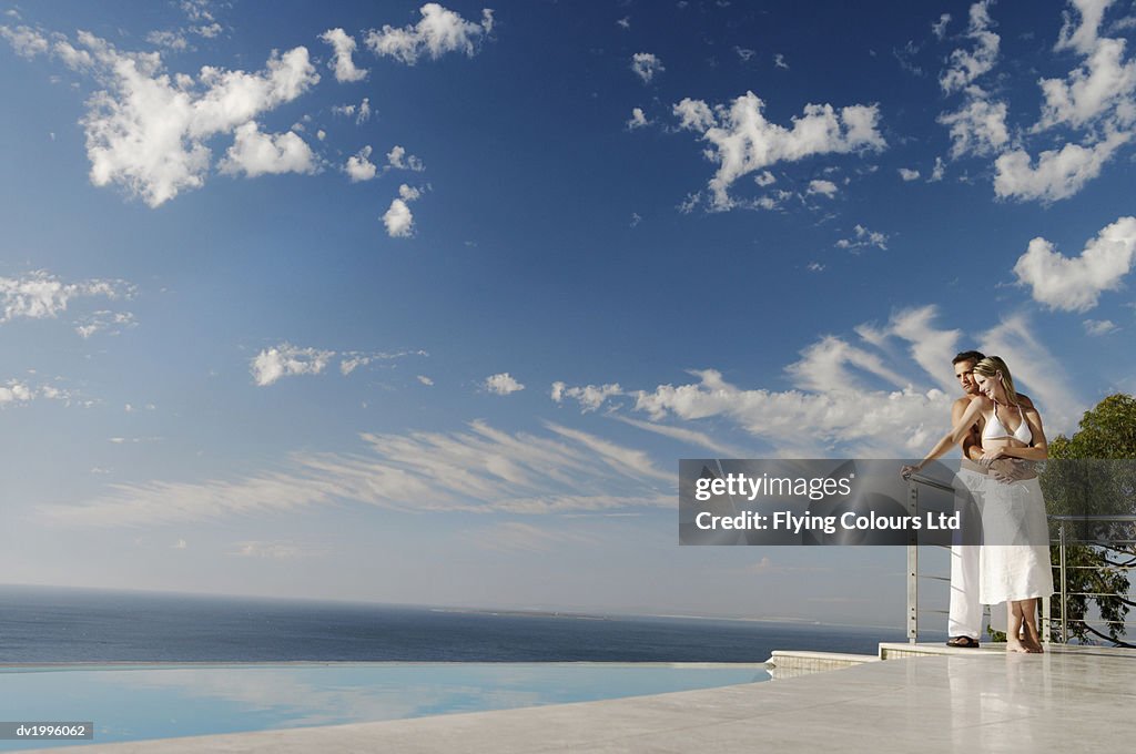 Couple Standing Poolside on a Scenic Coast