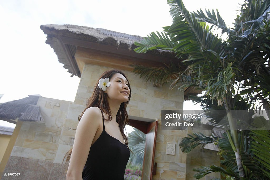 Woman Wearing a Flower in Her Hair Standing by Palm Trees