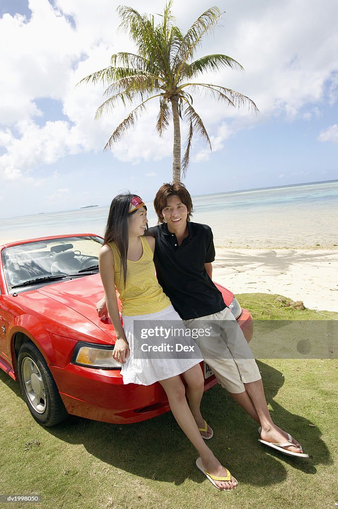 Couple Standing by a Convertible by the Beach