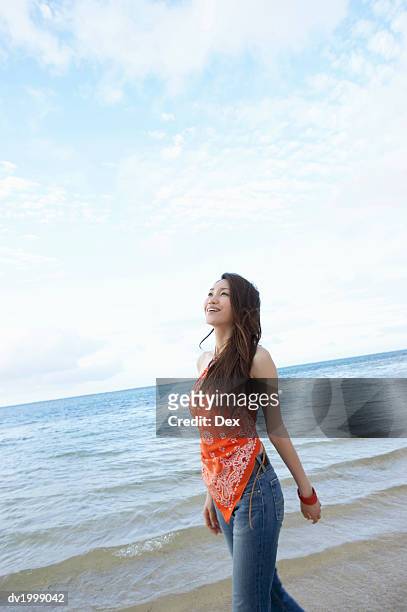 young woman walks by the sea, looking up with hope - hope photos et images de collection