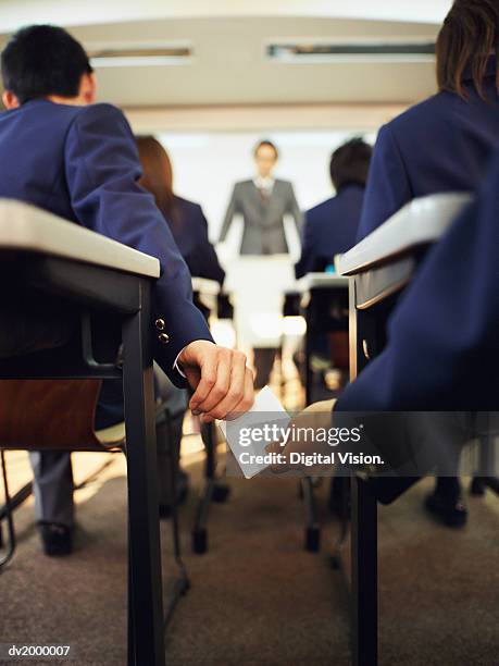 secondary school pupils in a classroom passing a note - secondary stock pictures, royalty-free photos & images