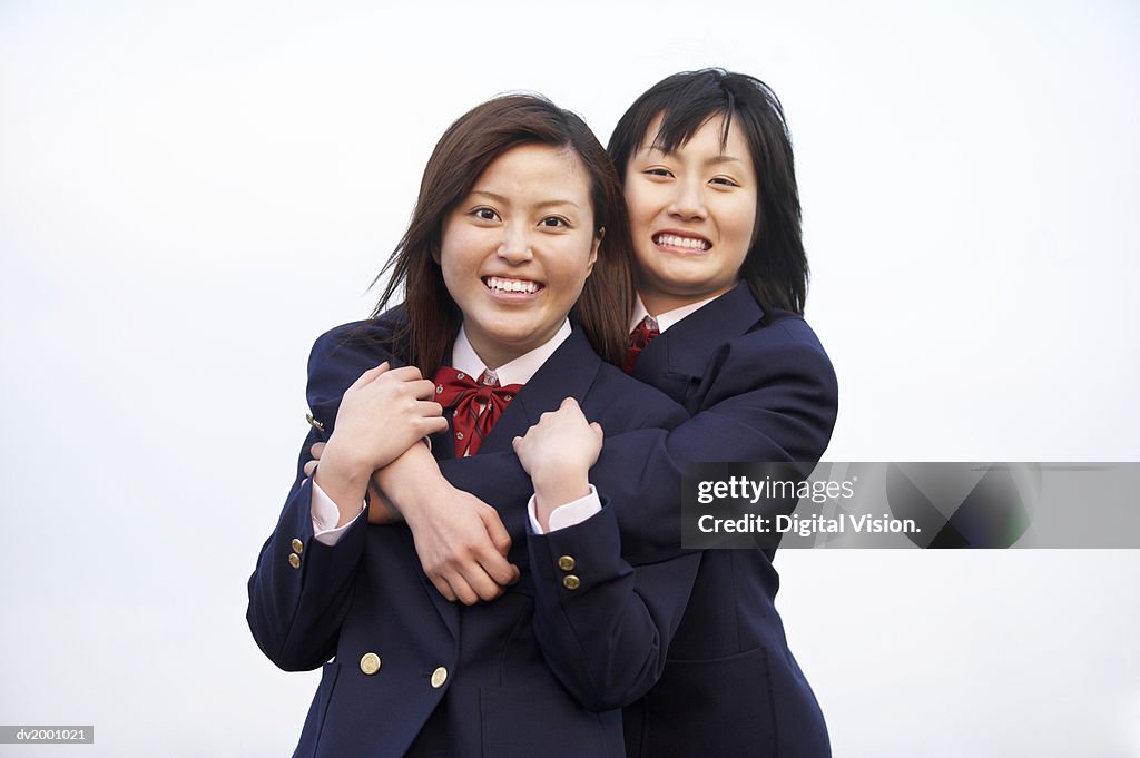 Portrait of Two Smiling Schoolgirls With Their Arms Around Each Other