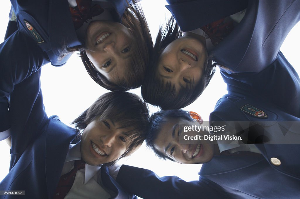 Portrait of Four School Friends With Their Arms Around Each Other From Below