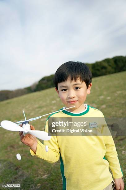 portrait of a young boy holding a toy plane - wonky fringe stock pictures, royalty-free photos & images