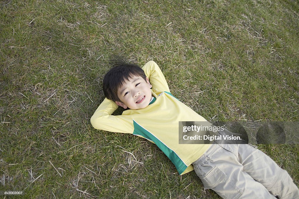 Portrait of a Small Boy Lying on Grass