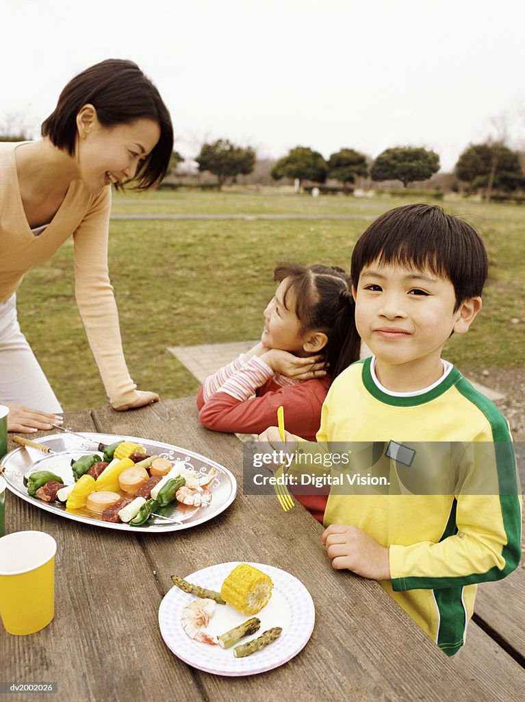 Family Eating Food at a Picnic Table