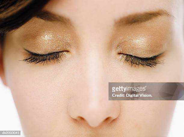 close up of a woman's eyes with golden make up - make up ストックフォトと画像