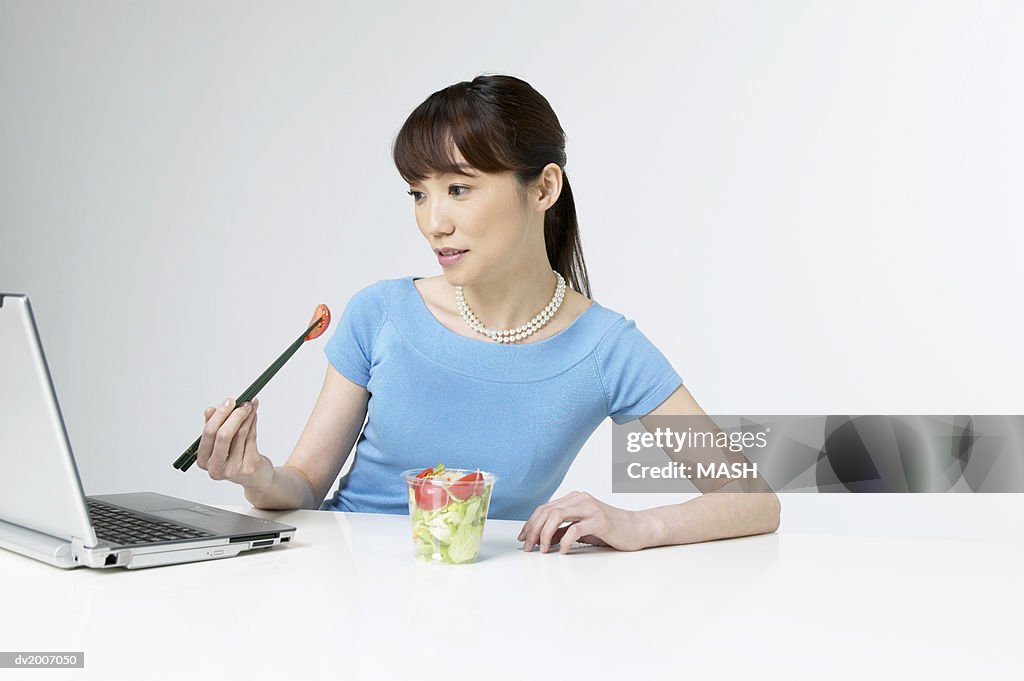 Businesswoman Eating a Salad at Her Desk