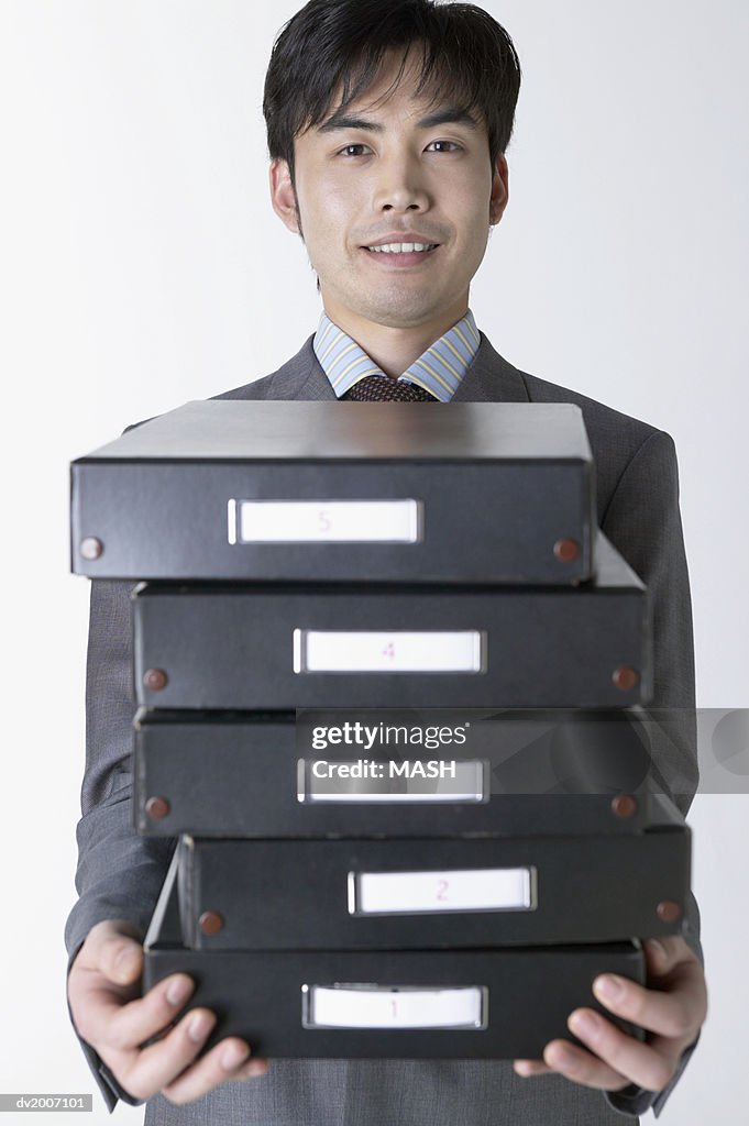 Businessman Carrying a Stack of Filing Boxes